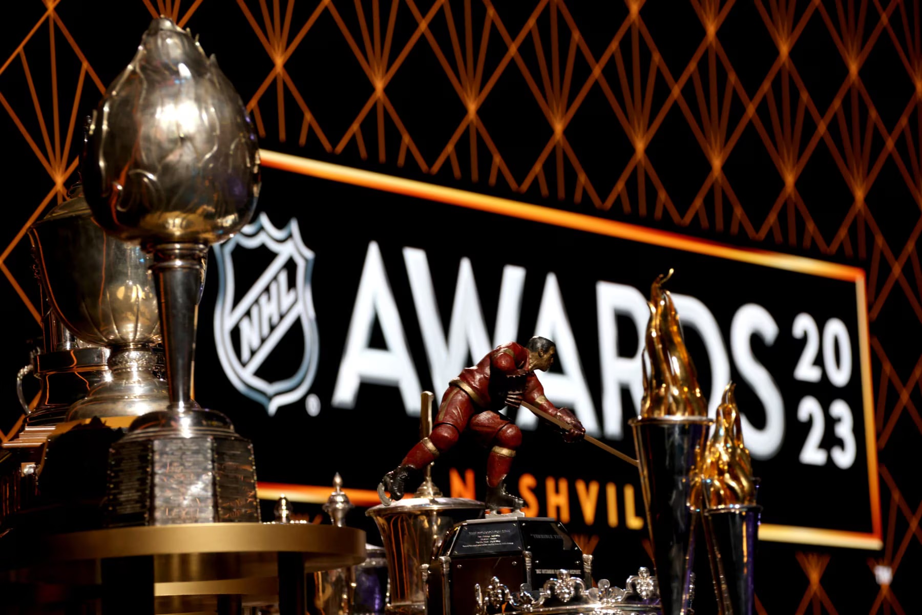 Silver and gold OTHL trophies arranged under warm light in front of the awards backdrop.